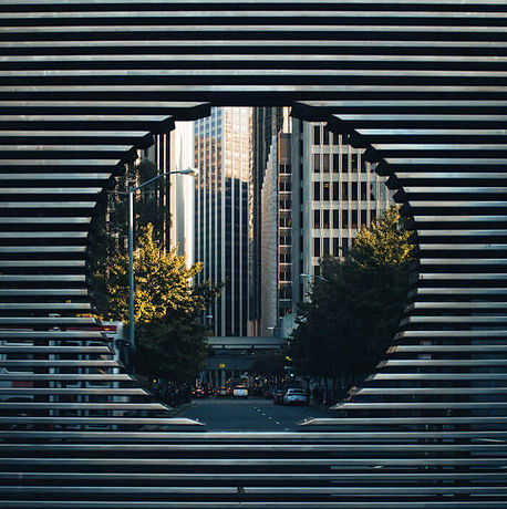 Modern office buildings viewed through an architectural structure