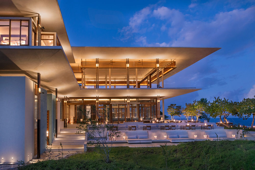 Amanera resort building lit at dusk with outdoor seating