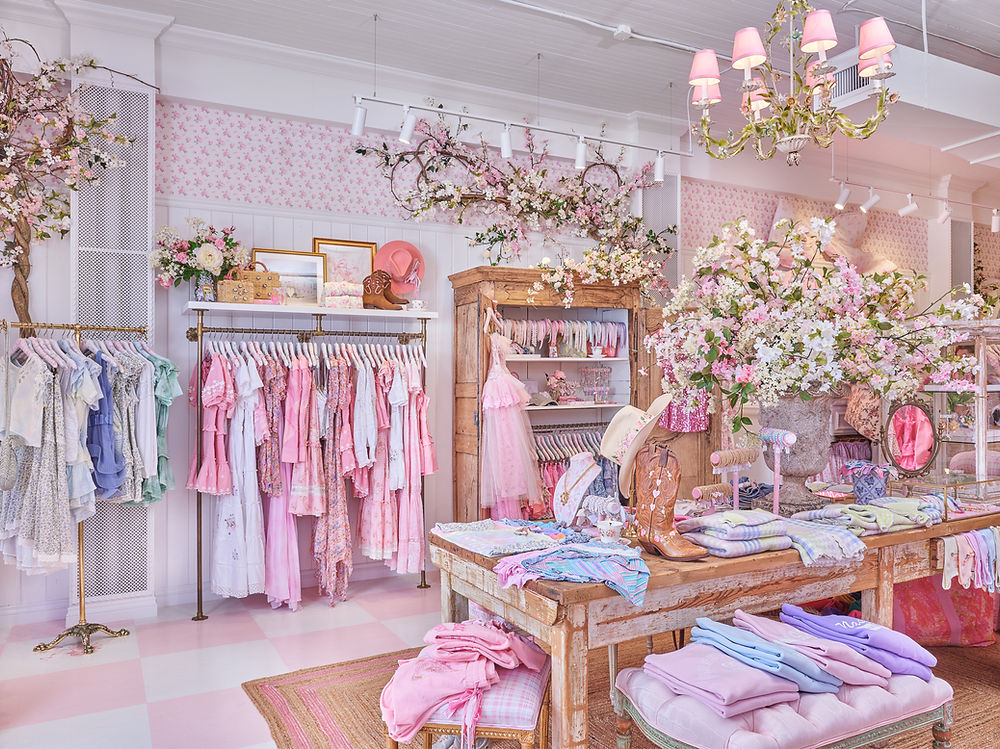 Pink boutique interior with dresses and floral decor