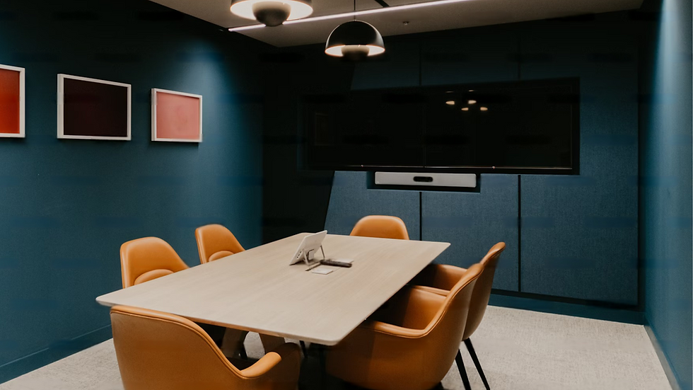 A meeting room with blue walls, yellow chairs, and three picture frames in different colors