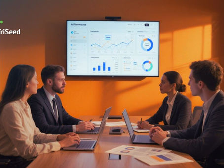 Four people in a meeting room, laptops open, discussing data charts on a screen. Orange wall background. Logo reads "TriSeed."