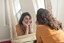 Image of a person looking confidently in the mirror, reflecting a positive sense of self-worth