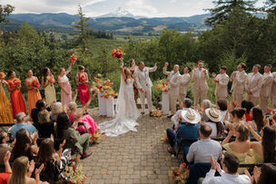 Bride and groom celebrating at the altar after their ceremony surrounded by vibrant floral arrangements designed by Philadelphia Event Decor with guests and sweeping Oregon mountain views.