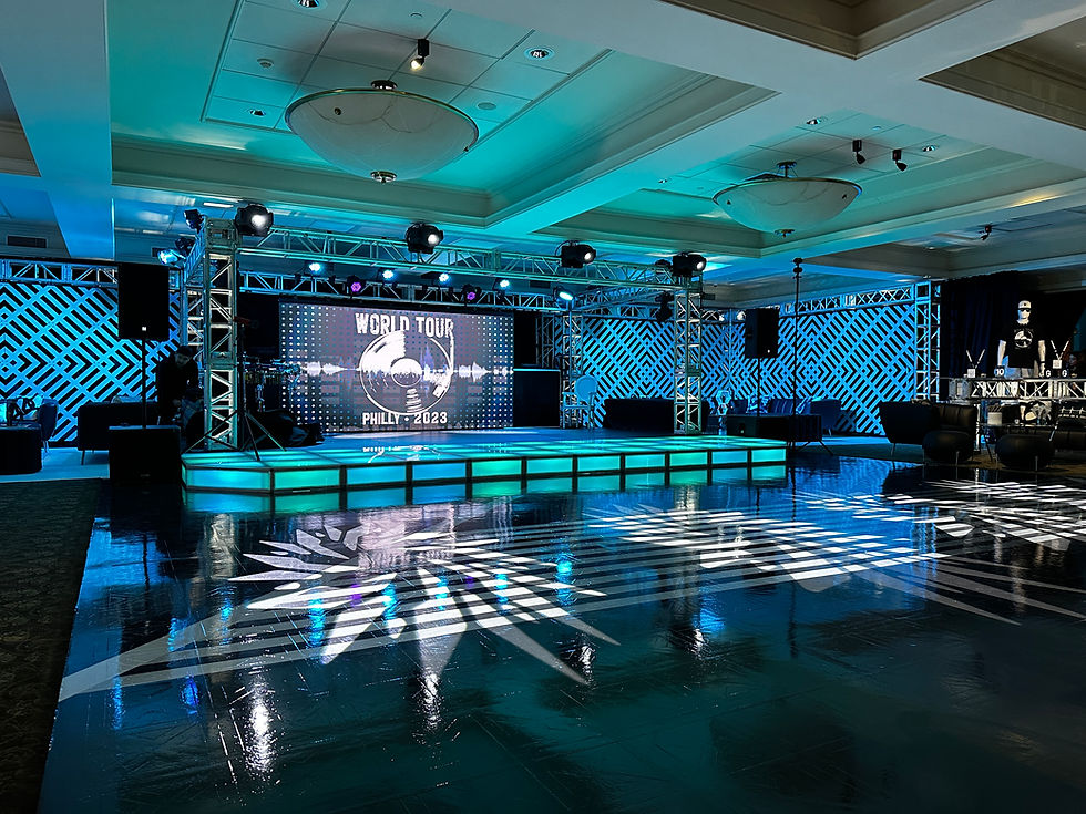 Large event staging and trussing rental with LED video screens, professional lighting, and custom dance floor effects.