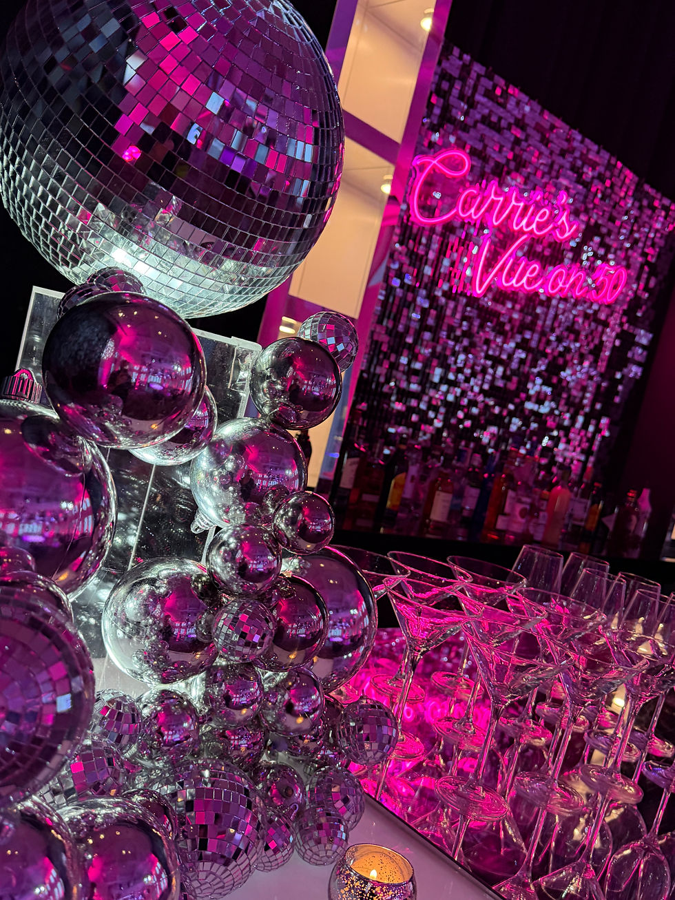 Disco-themed event prop rentals featuring mirrored disco balls, reflective décor, and a pink neon sign for a vibrant party.