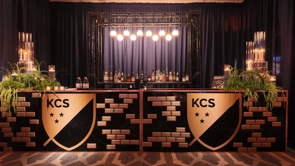 Custom branded statement bar with a coordinated back bar display, custom graphics, and elevated styling for a polished event experience.