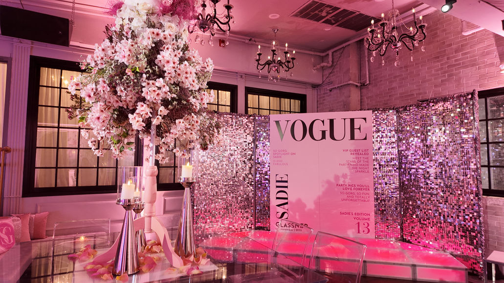 Custom fabrication and installation of a branded luxury magazine style photo booth featuring shimmering backdrop walls, custom graphics, and an immersive photo experience.