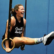Coach, Taryn Stratten, smiles while using rings at CrossFit Burleigh
