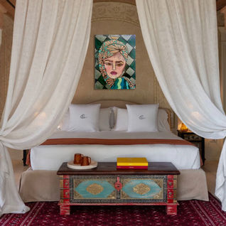 Portrait painting of a woman above a canopy bed