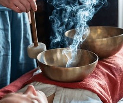Women using Tibetan singing bowels during a sound healing session