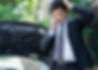 車の前で悩み、電話をかける男性