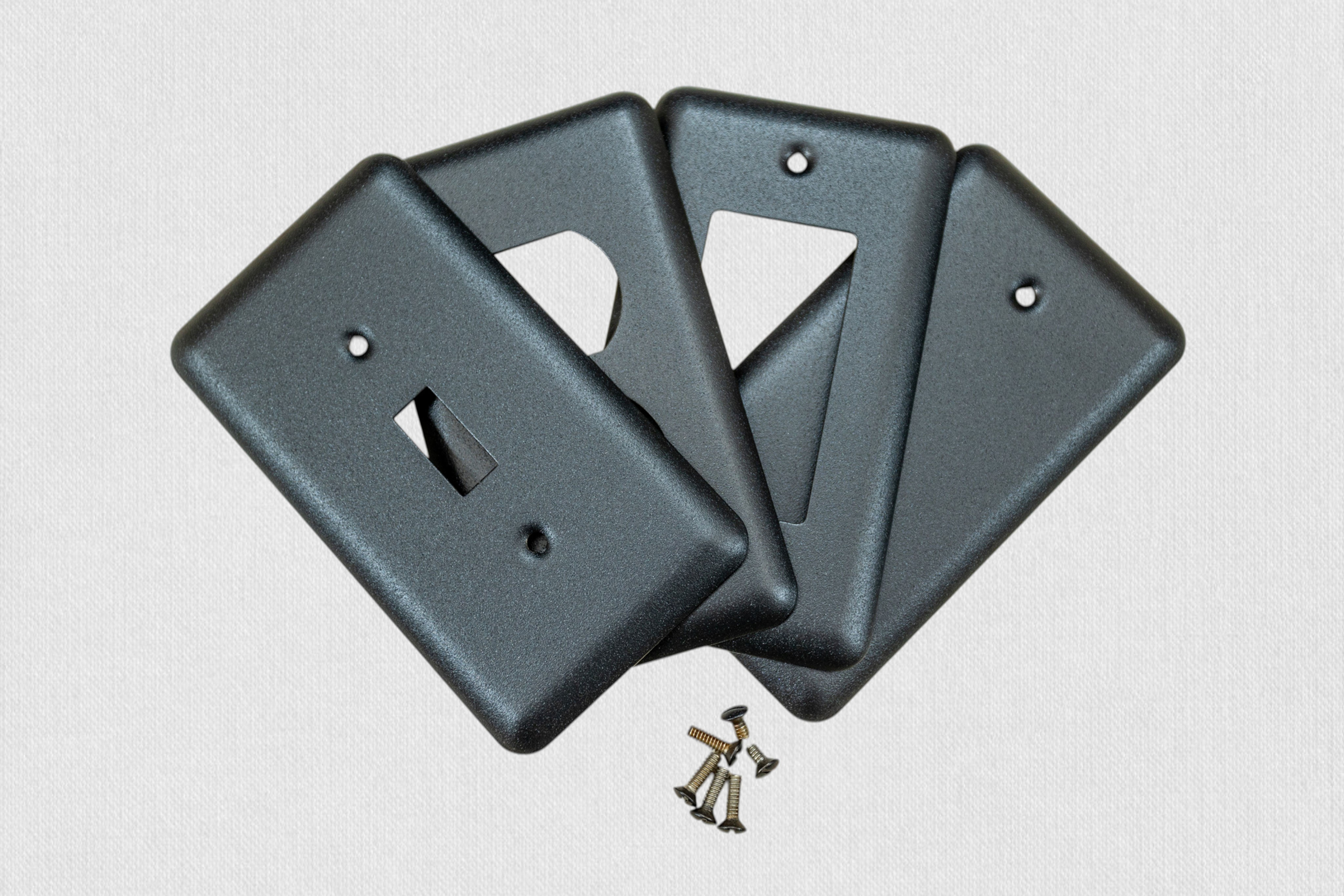 4 black switch plates on white background