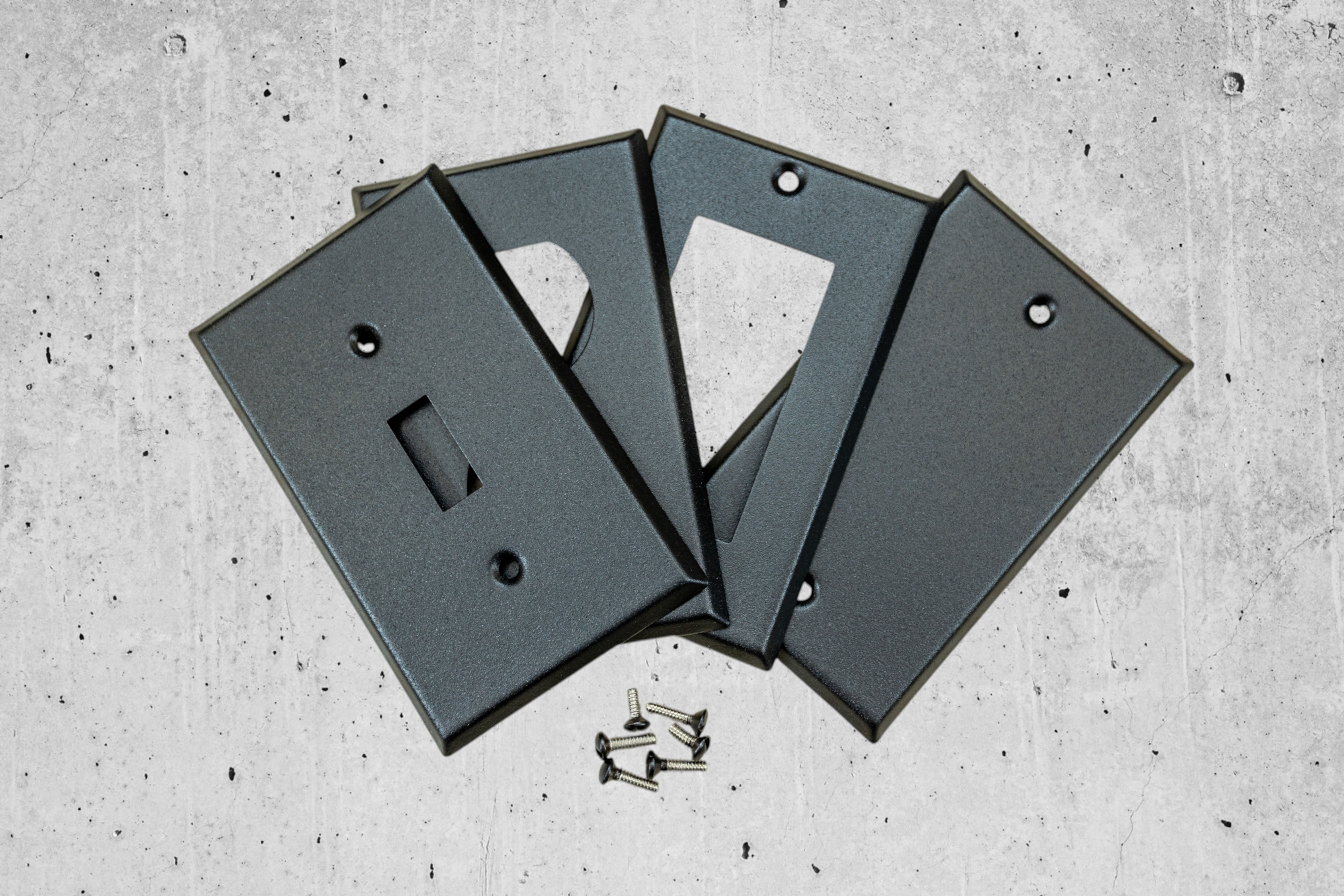 4 Black stone switch plates on white background