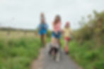 Dry Creek Estates in Ellensburg, WA abuts the Palouse to Cascades Trail where families enjoy outdoor adventures like this family of man, woman, and two girls walking their dog.