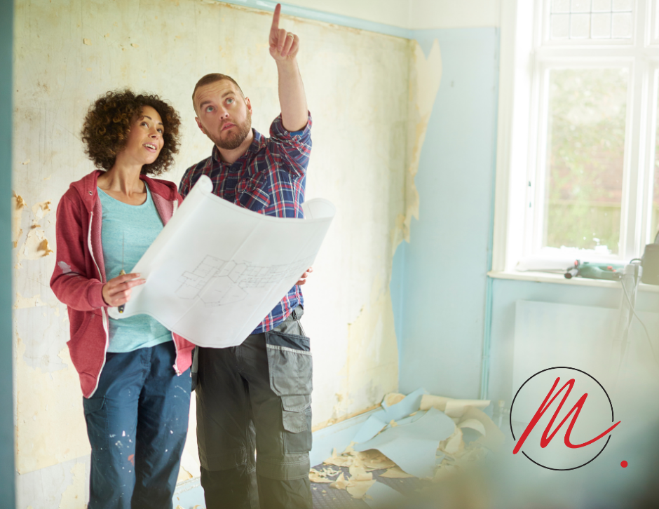 A couple looking at blueprints in a room that is under renovation. Plan your home remodelling in Red Deer with Marin Construction.