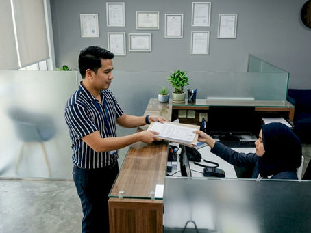Filipino expat handing official documents at service desk