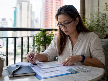 Filipino expat reviewing UAE attested documents at home