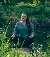 Photo of owner practicing mindfulness by a creek