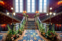 Historic venue staircase decorated with floral arrangements