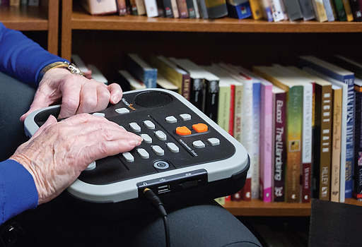 A senior lady playing her CD with a DAISY reader.