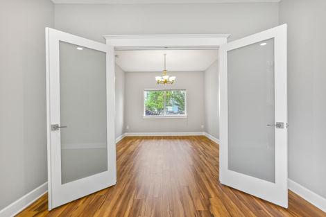 Interior remodel in Beaverton features newly installed warm vinyl wood flooring, light gray interior paint, and glass French doors.