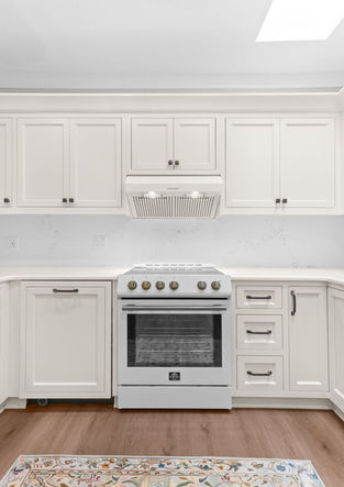 Cream kitchen cabinets paired with white appliances and updated lighting.