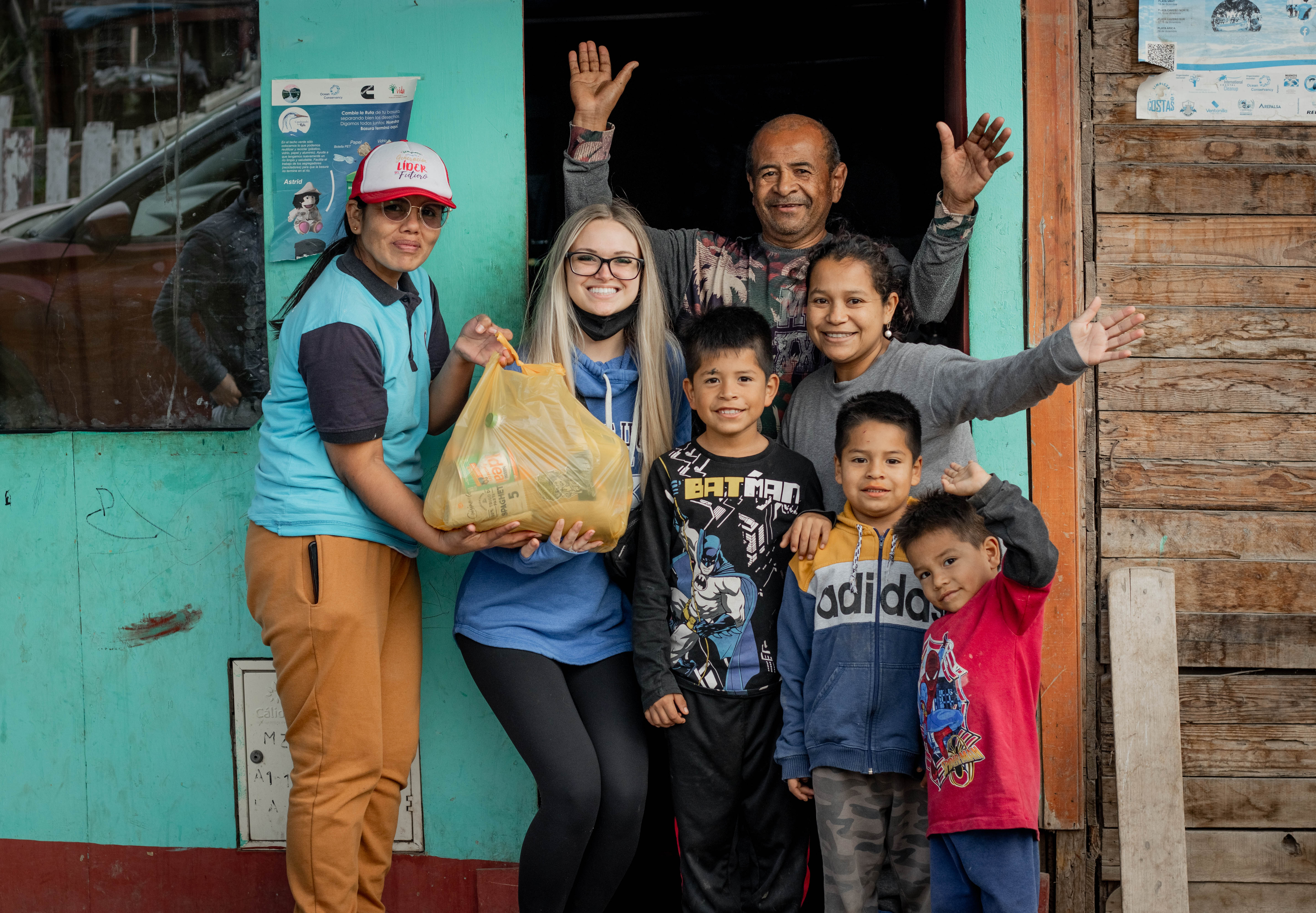 Family and Volunteers standing in front of a house