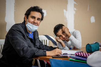 teacher and student sitting at a desk with homework