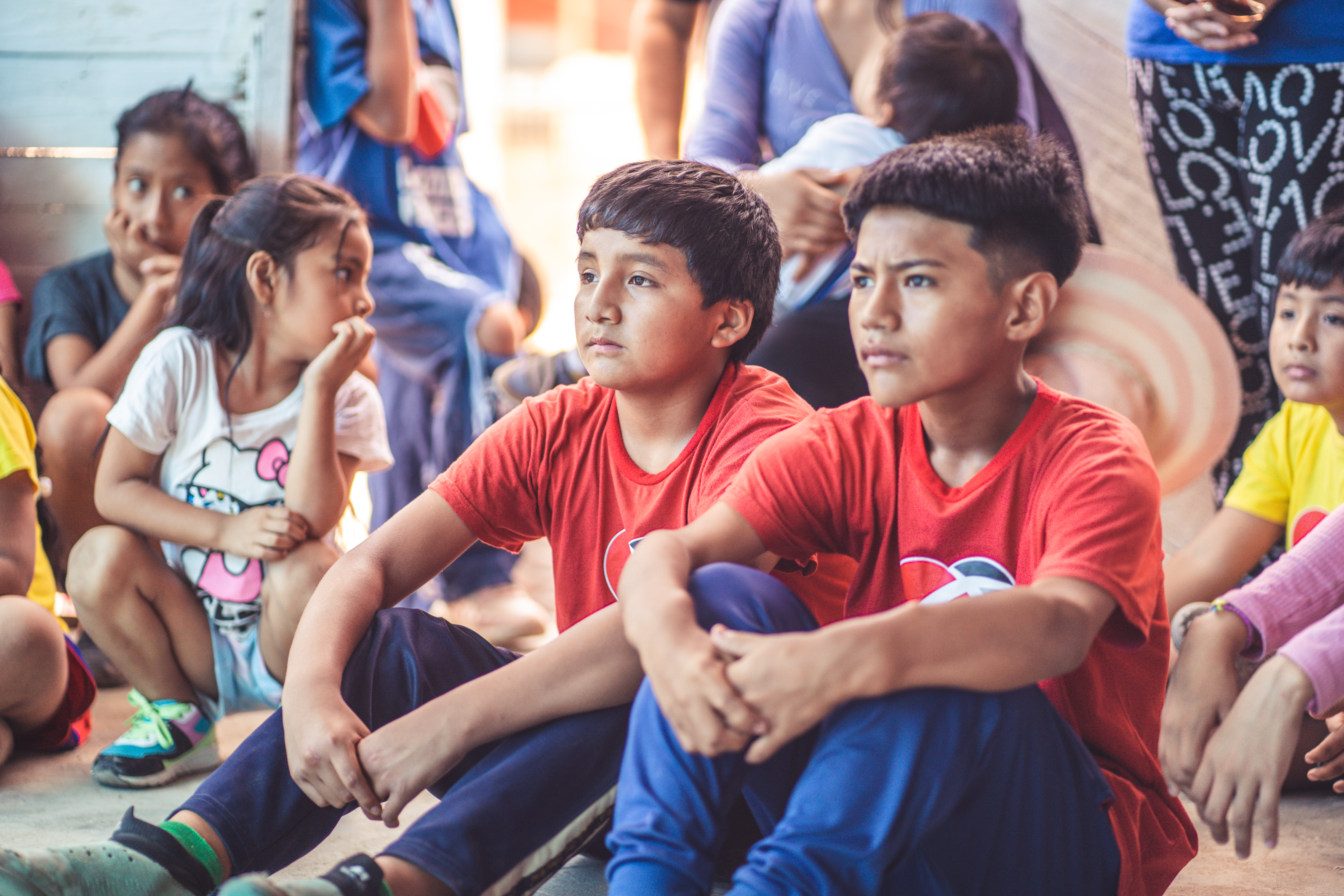 young kids sitting and listening to a teacher