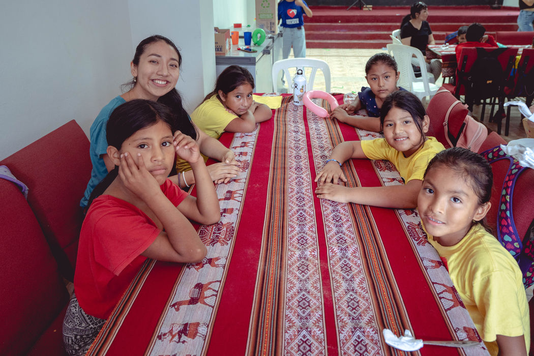 long table with kids on either side smiling at the camera