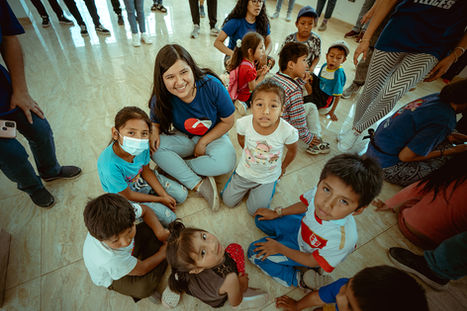 volunteer sitting a circle with young kids