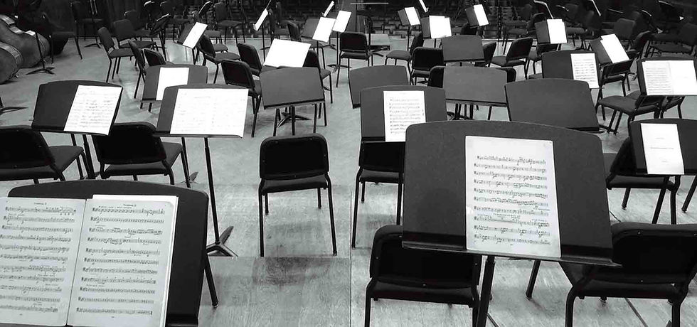 KW School of Music newsletter signup form with background of orchestra rehearsal room, sheet music, and chairs