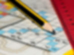 Yellow pencil and red ruler on a Sudoku puzzle with blue highlighted numbers against a colorful blurred background.