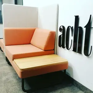 Bild von einer Couch, dahinter die Zahl 8 als Wort an der Wand montiert