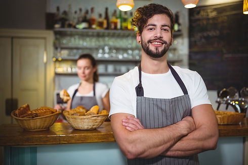 smiling-waiter-standing-with-arms-crosse