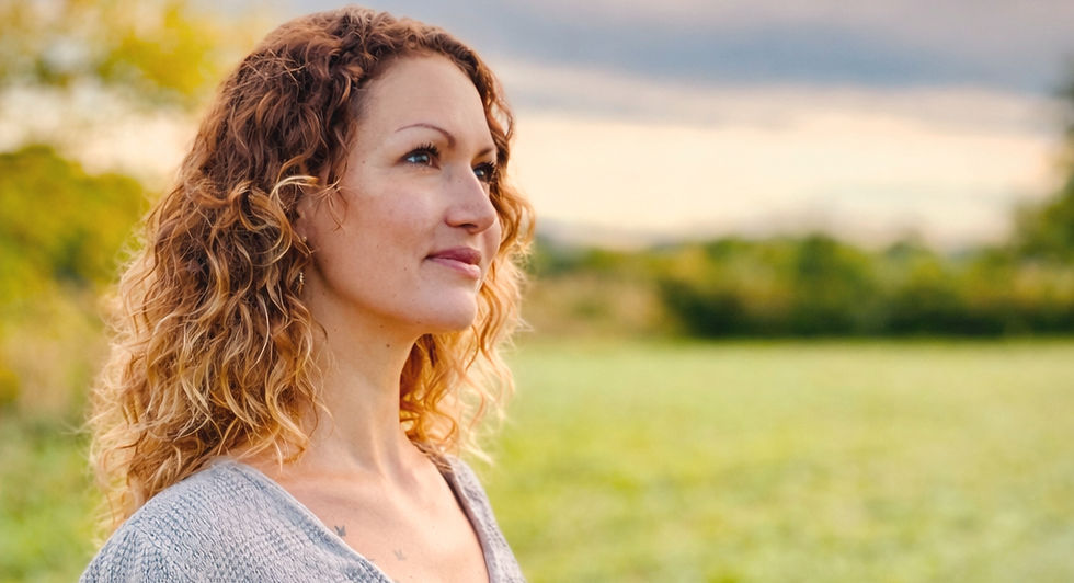 Annika Heinl, mit Blick in den Himmel, Bäume und Himmel im Hintergrund