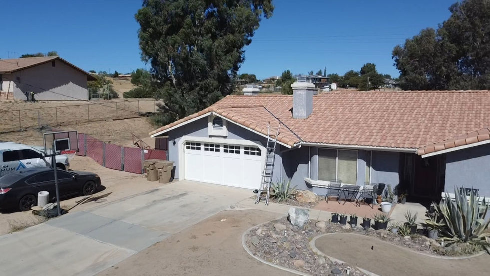 Front view of the Hesperia home with a tan tile roof above the garage and entrance.
