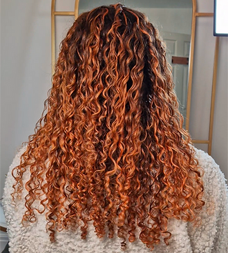 Wolverhampton, Tettenhall hairdresser adding a copper red colour to long curly hair, creating a stunning look
