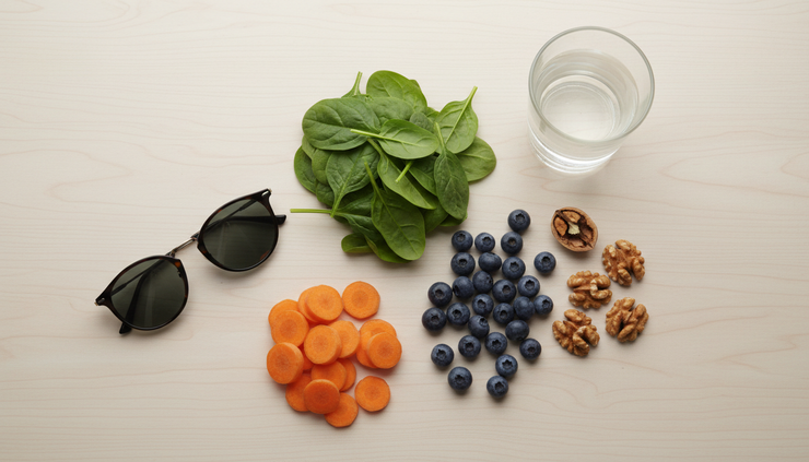 Vista cenital de gafas de sol y verduras frescas sobre una mesa de cocina