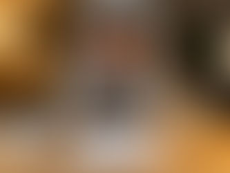 Giovane donna preoccupata osserva documenti finanziari, un modellino di casa e una vaschetta di ghiaccio che si scioglie, simbolo dell'erosione della liquidità e della difficoltà di scelta tra investimenti immobiliari, assicurativi e azionari.