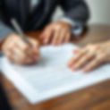 image containing a person signing a contract but focused on pen and paper.jpg