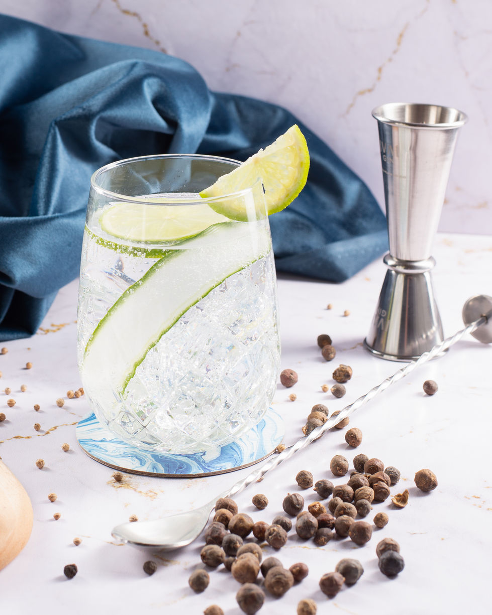 Gins da destilaria Ivaí com garrafas em relevo, drinks autorais e cenário elegante em mármore e natureza.