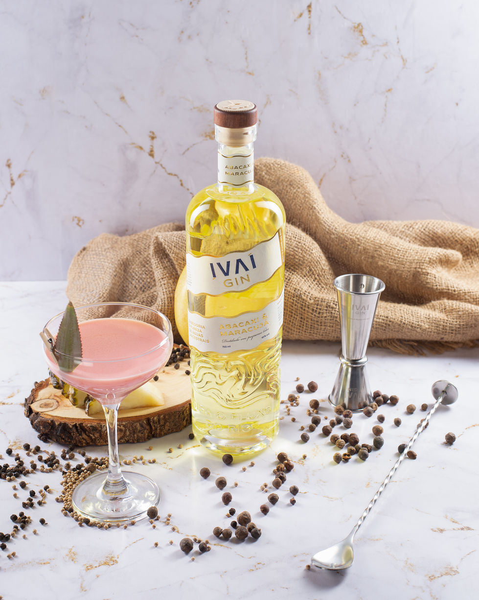 Gins da destilaria Ivaí com garrafas em relevo, drinks autorais e cenário elegante em mármore e natureza.