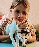 Célia enfant avec deux chats, illustrant son amour précoce pour les animaux.