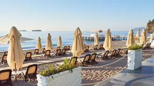Une personne âgé assise sur le bord de plage