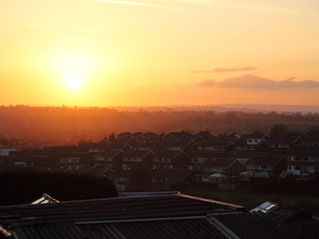 wildfire smoke creates smoky sunrise haze over a city