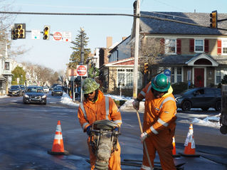 Two workers repairing road in winter