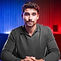 Iman Gadzhi in a suit with red and blue lighting, representing business authority or digital coaching