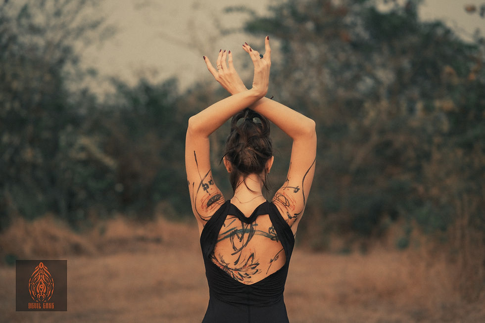 Thumbnail: Woman with tattoos, arms crossed, black dress, outdoors, Catana Clothing.