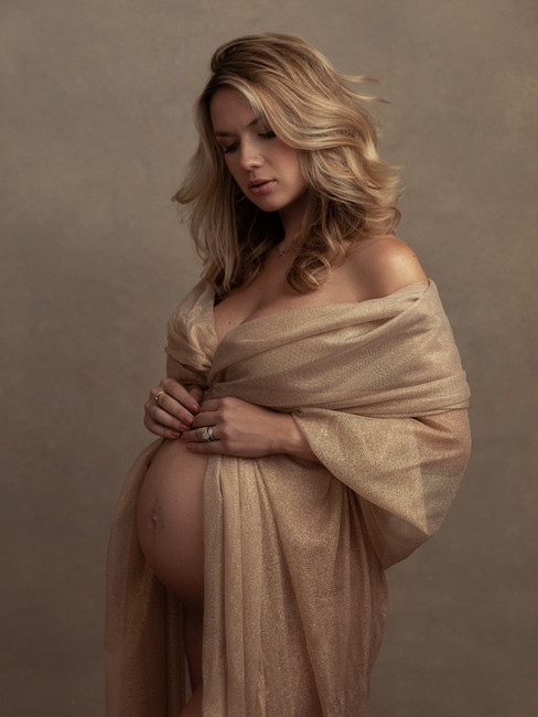 Studio maternity portrait of an expecting mother in a timeless neutral dress photographed by Alice Prenat in NYC.